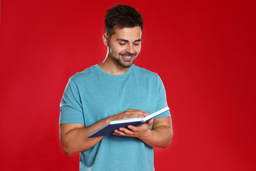 Sticker - Handsome young man reading book on red background