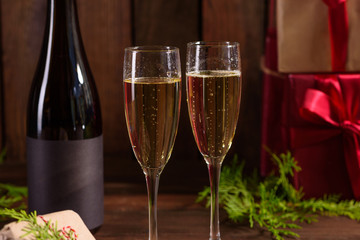 Christmas holiday table with glasses and a bottle of wine of champagne. Eve of new year, preparation and laying of a wooden holiday table