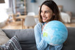 © BestForYou - Portrait of a beautiful happy woman with a globe indoors.