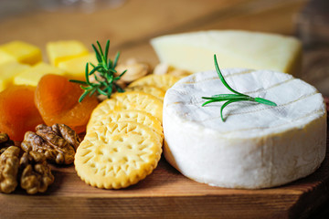 Wall Mural - cheese plate,camembert cheese ,rosemary ,crackers,dry apricot and walnuts