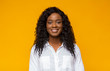 Pretty black girl smiling on studio yellow background