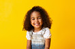 Leinwandbild Motiv Happy smiling african-american child girl, yellow background