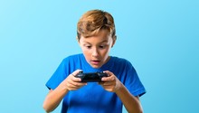 Kid Playing The Console On Blue Background
