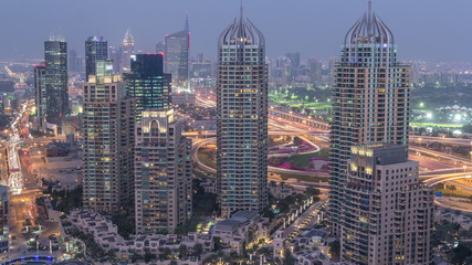  Aerial top view of Dubai Marina day to night timelapse. Modern towers and traffic on the road