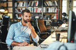 © Friends Stock - Good working day. Young bearded businessman in formal wear touching his chin and thinking about something while sitting in modern office