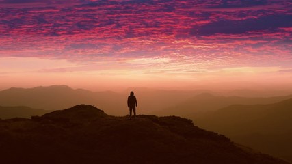 Wall Mural - the man standing on a mountain top against the beautiful sunset