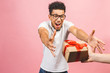 © denis_vermenko - Cheerful smiling african american millennial guy in eyewear holding wrapped present box. Happy black young man congratulating, giving birthday gift, isolated on pink background.
