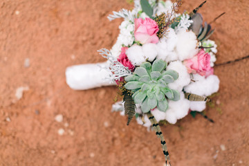 Wall Mural - Modern flower wedding boutique with cotton, pink roses, and succulents, dessert wedding, red dirt background