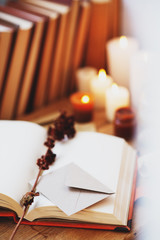 Sticker -  homeliness, hygge, candles, old books, diary and dried flowers on a wooden background, vintage