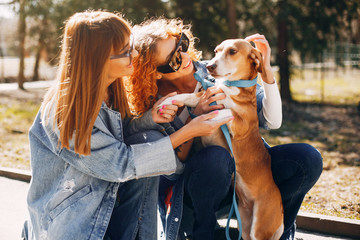 Wall Mural - Beautiful girl in a park. Stylish woman in a jeans jacket. Ladies with a dog