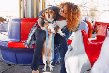 Wall Mural - Beautiful girl in a park. Stylish woman in a jeans jacket. Ladies with a dog