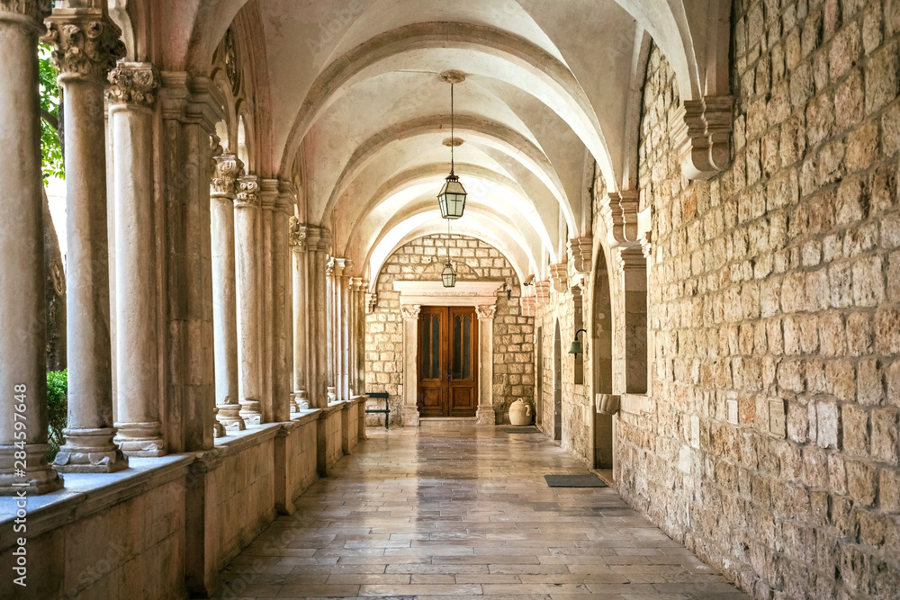 Courtyard with columns and arches in old Dominican monastery in Dubrovnik, Croatia - obrazy, fototapety, plakaty 