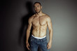 Muscle strong beautiful stripped male model with white underwear in denim blue jeans on black isolated font 