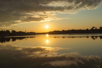 Wall Mural - The orange light of a beautiful sunset is reflected in the eagle creek at Marinette,WI.