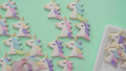 Poster - Flat lay. Unicorn sugar cookies decorated with royal icing and food glitter on a blue background.