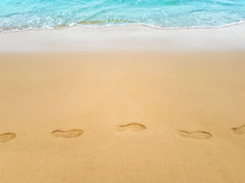 Footprints In Sand On Sea Coast. Print On Beach Top View