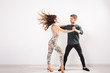 © satura_ - Young couple dancing latin dance bachata, merengue, salsa, kizomba. Two elegance pose over white background with copy space