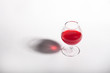 © Ирина Коннова - Glass goblet with red drink on a white background. With a shadow from a glass of Minimalism.