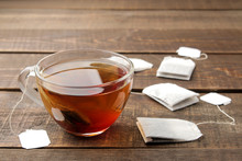 Tea Bag In A Glass Cup On A Brown Wooden Background. To Make Tea