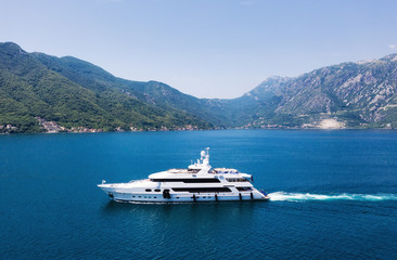 Wall Mural - View on the luxury yacht in Montenegro. Blue sea water background from air. Mountains and sea landscape. Summer seascape from air. Travel - image