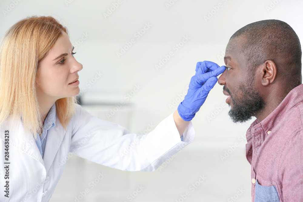 African-American man meeting with plastic surgeon in clinic