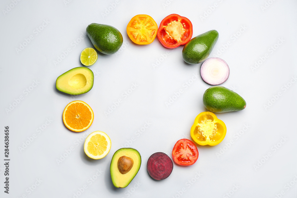 Frame made of avocado, fruits and vegetables on light background