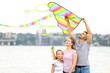 © Pixel-Shot - Happy family flying kite near river