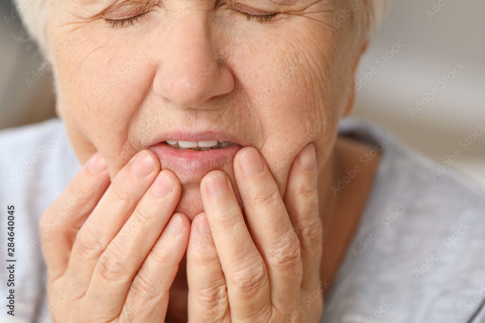 Senior woman suffering from toothache, closeup