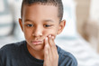 © Pixel-Shot - Little African-American boy suffering from toothache at home