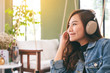 © Farknot Architect - A beautiful asian woman enjoy listening to music with headphone with feeling happy and relaxed in cafe