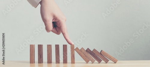 Fotomural Hand stopping wooden domino business crisis effect or risk protection concept