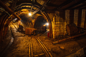 Underground mining tunnel with rails. Copy space. Work in an underground coal mine