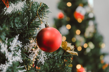 Merry Christmas. close up red color decorated ball hanging on christmas tree with bokeh light background, holiday family, happy new year and merry christmas festival concept, vintage color tone effect