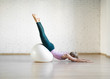 © junky_jess - Slender caucasian girl doing pilates balance with big fit ball in fitness studio, upside down pose, selective focus.