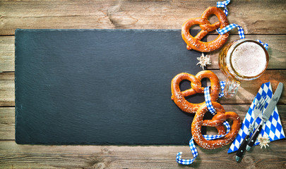 Wall Mural - Bavarian pretzels with silverware and beer stein on wooden table.