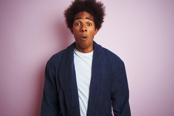 Sticker - Young african american man wearing pajama standing over isolated pink background afraid and shocked with surprise expression, fear and excited face.