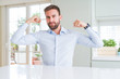 © Krakenimages.com - Handsome business man showing arms muscles smiling proud. Fitness concept.