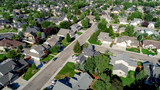 Fototapeta  - Main street leads through a subdivision with homes and trees