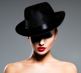 Сlose-up portrait of a woman in a black hat  with red lips