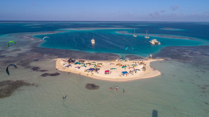 Aerial view island with kiters doing kiteboarding  and wind sur sports on the Caribbean beach f in Los Roques Archipelago Venezuela