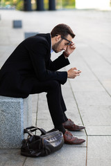 Wall Mural - Modern young man playing on phone, browsing mobile news. Gadget Dependence.