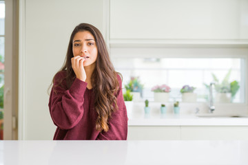 Poster - Young beautiful woman at home looking stressed and nervous with hands on mouth biting nails. Anxiety problem.