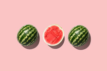 Three Halves Of Watermelon In A Row Isolated On Pink Background.