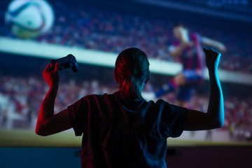 Poster - soccer game, girl gamer playing a game in football headphones on a big screen, with bright light and