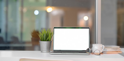 trendy home-office with open blank screen laptop computer