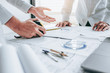 © Nichapa - Team Engineer drawing graphic planning and meeting for architectural project on workplace