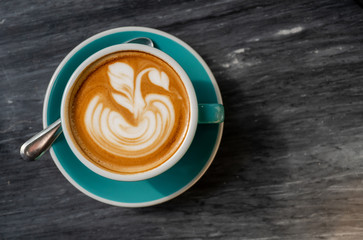 The latte art coffee served within ceramic cup