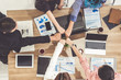 © InfiniteFlow - Businessmen and businesswomen joining hands in group meeting at multicultural office room showing teamwork, support and unity in business. Diversity workplace and corporate people working concept.
