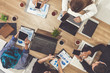 © InfiniteFlow - Top view of businessman executive in group meeting with other businessmen and businesswomen in modern office with laptop computer, coffee and document on table. People corporate business team concept.