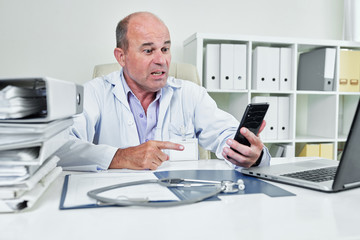 Angry emotional general practitioner in labcoat video calling coworker or annoying patient